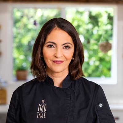 Chef Patty Morrell-Ruiz in a black The Mad Table chef coat in her kitchen