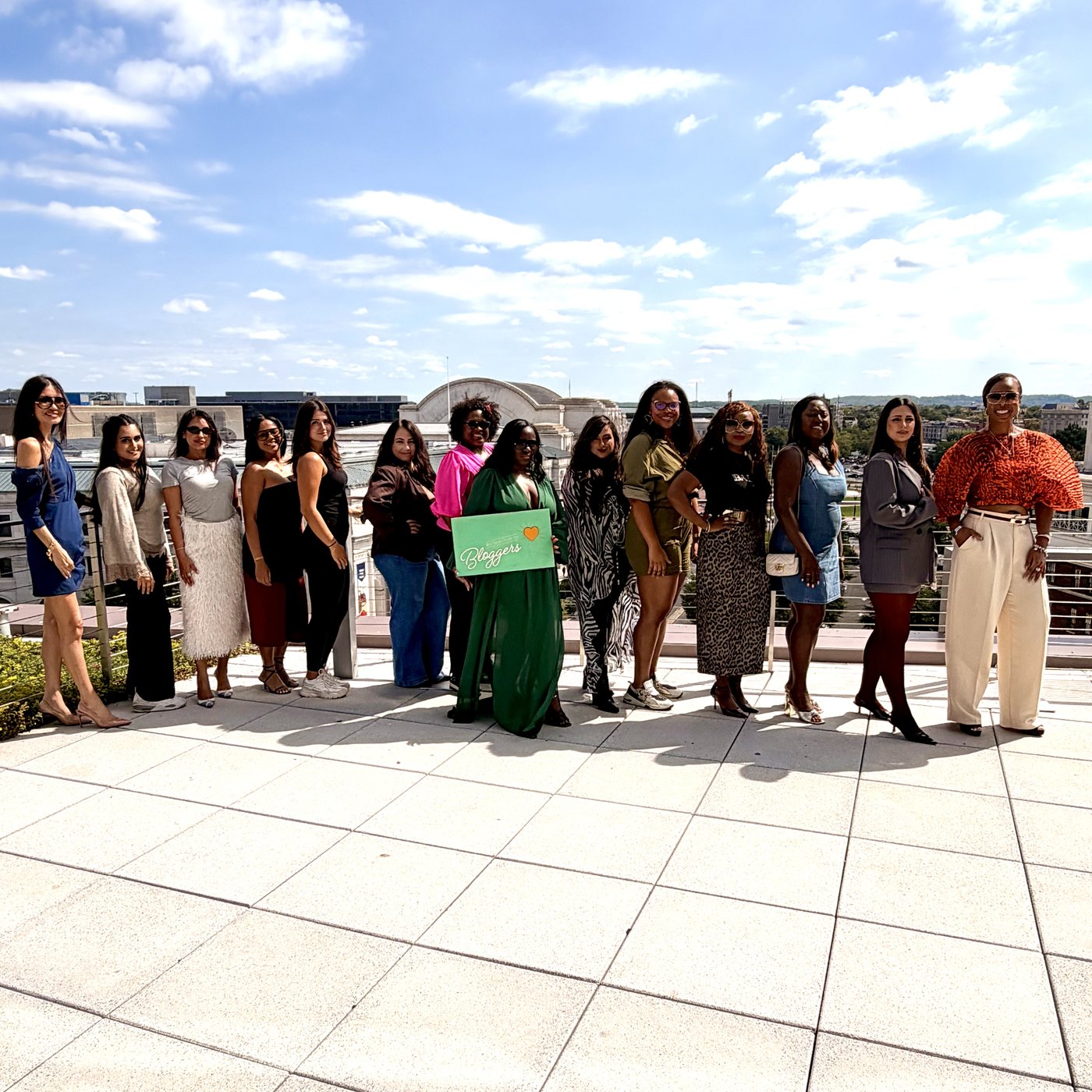 DC Bloggers group photo on the rooftop terrace at The Royal Sonesta Capitol Hill, one attendee holding the DC Bloggers sign