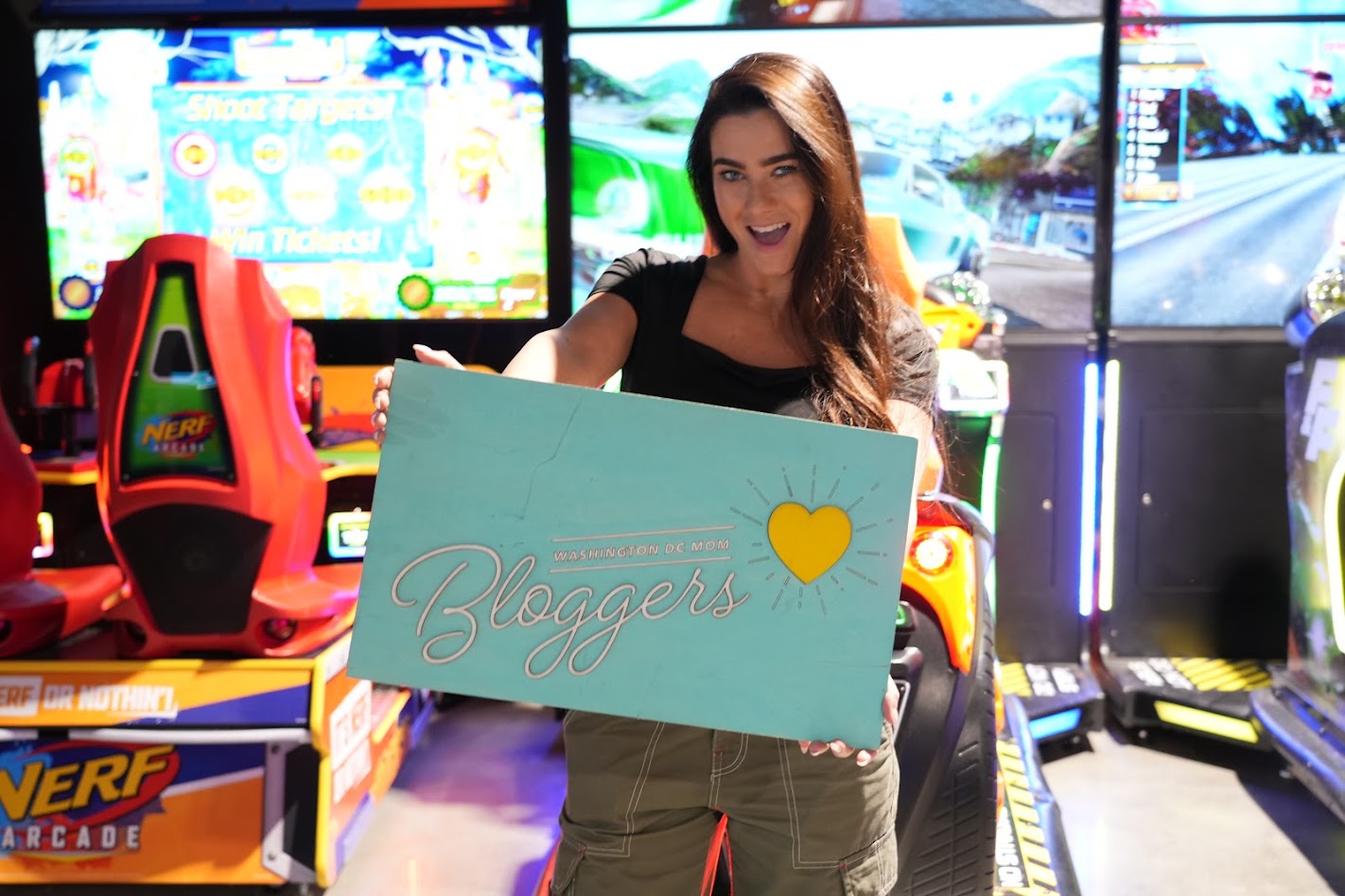 A DC Mom Blogger holding the Washington DC Mom Bloggers sign at 810 Entertainment