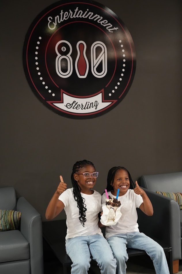 Two sisters with a sundae under the 810 Entertainment Sterling sign